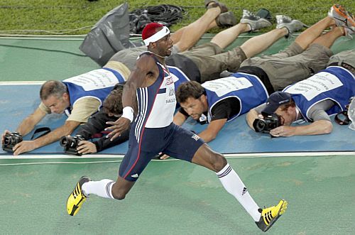 Enquanto o atleta britânico Philips Idowu executa o salto triplo, durante a final do Campeonato Europeu de Atletismo, em Barcelona, os fotógrafos deitam no chão, buscando o melhor ângulo. Foto: Kai Försterling/EFE