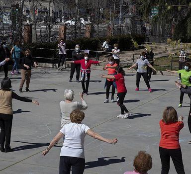 Um grupo de mulheres se exercita com música em um parque em Madrid.