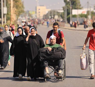 TOPSHOT - Palestinians fleeing Gaza City towards the southern areas walk on a road on November 7, 2023, amid the ongoing battles between Israel and the Palestinian Islamist group Hamas. Thousands of civilians, both Palestinians and Israelis, have died since October 7, 2023, after Palestinian Hamas militants based in the Gaza Strip entered southern Israel in an unprecedented attack triggering a war declared by Israel on Hamas with retaliatory bombings on Gaza. (Photo by MAHMUD HAMS / AFP)