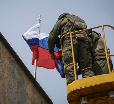 Svitlodarsk (Ukraine), 26/05/2022.- Igor Zakharevich (L), the militant-appointed mayor of Debaltseve, arranges the flags of Russia and the self-proclaimed Donetsk People's Republic at the city administration building of Svitlodarsk, Donetsk region, Ukraine, 26 May 2022. Russia has taken control of the city of Svetlodarsk, located 80 km southwest of Severodonetsk, which was the center of Russian attacks in recent days. On 24 February Russian troops had entered Ukrainian territory in what the Russian president declared a 'special military operation', resulting in fighting and destruction in the country and a humanitarian crisis. (Atentado, Rusia, Ucrania) EFE/EPA/ALESSANDRO GUERRA
