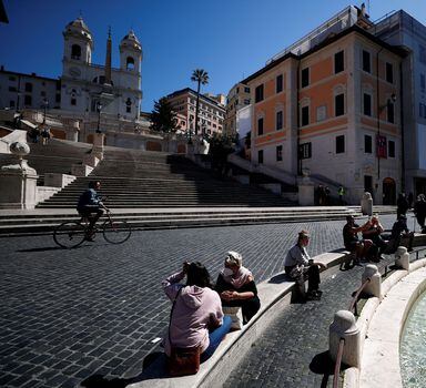 FILE PHOTO: People wearing masks sit near the Spanish steps as COVID-19 restrictions in the Lazio region are slightly relaxed, in Rome, Italy March 30, 2021. REUTERS/Guglielmo Mangiapane/File Photo