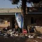 An Israeli flag hangs between destroyed homes in kibbutz Kfar Azza, Israel, near the Gaza Strip, on Nov. 13, 2023. The kibbutz was attacked during the Hamas cross-border attack on Oct. 7, killing and capturing members of its community. (AP Photo/Leo Correa)