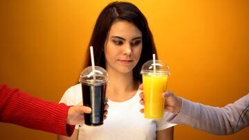 Girl choosing between orange juice and soda, vitamin drink or unhealthy diet. Foto: motortion/Adobe Stock 