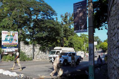 Membros das forças policias do Haiti ao lado de uma imagem do presidente assassinado, Jovenel Moise. Mercenários colombianos foram acusados de terem matado o presidente, mas suas famílias alegam que eles foram enganados