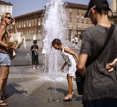 Italianos aproveitam fonte para se refrescar na Praça Castelo, em Turim, no norte da Itália