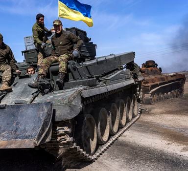 Soldados ucranianos rebocam um tanque russo danificado em um campo perto da vila de Lypivka, a oeste de Kiev; Rússia pede que governo Biden interrompa envio de armas avançadas para a Ucrânia