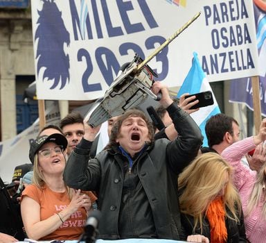 Picture released by AG La Plata showing the presidential candidate for La Libertad Avanza party, Javier Milei (C), waving a chainsaw between his sister Karina Milei (R) and Buenos Aires Province governor candidate Carolina Piparo, during a political rally in La Plata, Buenos Aires Province, Argentina, on September 12, 2023. Argentina holds presidential elections on October 22, 2023. With a month to go, the election remains eminently open and the economy at the heart of the debates, with a great divide between the ultraliberal Javier Milei's promise to "slash" public spending and the government camp's showering of subsidies to "lend a hand" to Argentines bled dry by inflation. His main rivals will be former security minister Patricia Bullrich on the right, and economy minister Massa from the ruling centre-left coalition. (Photo by Marcos GOMEZ / AG La Plata / AFP) / RESTRICTED TO EDITORIAL USE - MANDATORY CREDIT "AFP PHOTO / AG LA PLATA / MARCOS GOMEZ" - NO MARKETING - NO ADVERTISING CAMPAIGNS - DISTRIBUTED AS A SERVICE TO CLIENTS