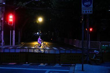 Residente de Xangai dirige sua bicicleta por ruas esvaziadas da cidade, sob lockdown. Foto: Aly Song/Reuters 