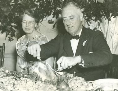 A primeira-dama Eleanor Roosevelt ao lado do marido, o presidente Franklin D. Roosevelt num jantar de ação de graças em novembro de 1935