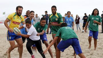 Young players play with members of Brazil's rugby team as they take part in the opening of a new rugby pitch which is installed on Copacabana beach in Rio de Janeiro, Brazil, June 24, 2015.  Brazil, as Olympic hosts, has an automatic place for the Rugby Sevens competition which enters the Olympics for the first time at Rio 2016. The largely amateur team will not be among the favourites to take a medal, but they have seen it as an opportunity to raise awareness of the sport with the help of local and international federations and charities like UmRio. Rugby is now one of the fastest-growing sports in Brazil, with more than 46,000 children playing for the first time in the past two years, according to World Rugby. REUTERS/Sergio Moraes
. Foto: Sergio Moraes/ Reuters