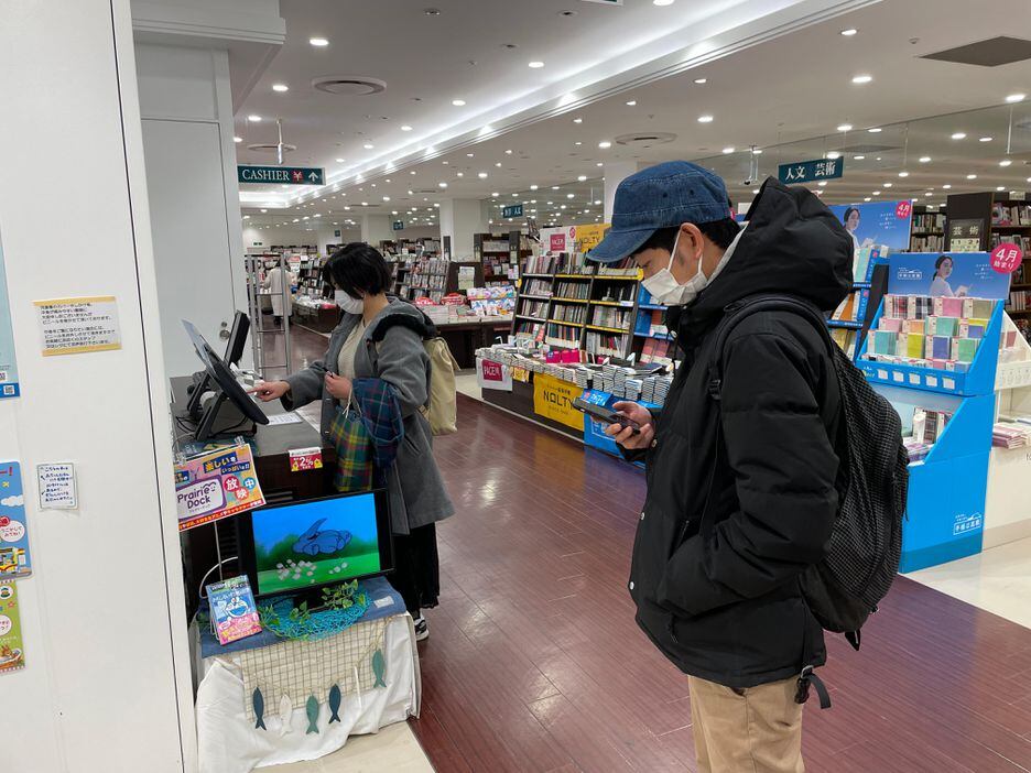 Depois do almoço, Akari Shirai visita livraria e compra cópia de livro de Shoji Morimoto.