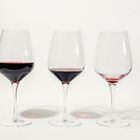 Three glasses with less amount of red wine poured in each, isolated on white. Mindful drinking and alcohol cutback. Foto: Diana Vyshniakova/Adobe Stock      