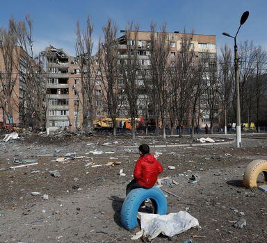 A boy sits in front of a residential building damaged by shelling during Ukraine-Russia conflict in the separatist-controlled city of Donetsk, Ukraine March 30, 2022. REUTERS/Alexander Ermochenko