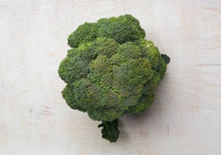 Um ramo de brócolis sobre uma superfície lisa e clara