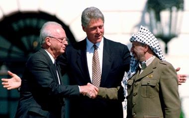 Yitzhak Rabin (esq.) e Yasser Arafat apertam as mãos após assinarem o acordo de paz entre israelenses e palestinos