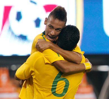 Brazil's Neymar (top) celebrates in the arms of Andre Santos after Neymar scored the first goal against the United States in the first half during their international friendly match at the New Meadowlands stadium in East Rutherford, New Jersey, August 10, 2010.  REUTERS/Mike Segar   (UNITED STATES - Tags: SPORT SOCCER)