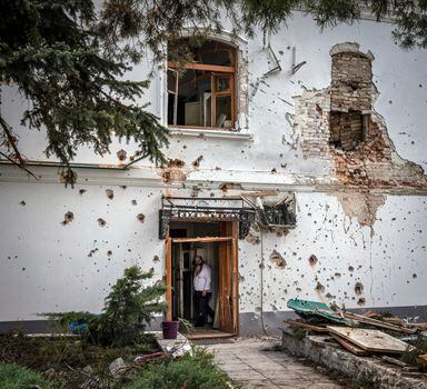 A monk in the doorway of a building heavily damaged by Russian artillery at the Sviatohirsk Monastery of the Caves in Sviatohirsk, Ukraine, June 3, 2022. The monks and nuns cloistered at the monastery complex in eastern Ukraine absorb daily bombardments from Russian artillery, but they remain loyal to the Russian Orthodox Church. (Ivor Prickett/The New York Times)