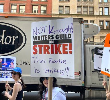 Picketers carry signs outsie of Netflix on Wednesday, Aug. 9, 2023, in New York. The Hollywood writers strike reached the 100-day mark today as the U.S. film and television industries remain paralyzed by dual actors and screenwriters strikes. (AP Photo/Jocelyn Noveck)