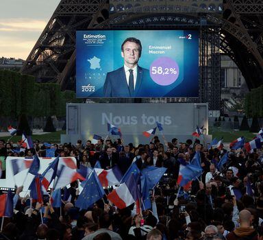 Supporters of French President Emmanuel Macron,  candidate for his re-election,  react after results were announced in the second round vote of the 2022 French presidential election, near Eiffel Tower, at the Champs de Mars in Paris, France April 24, 2022. REUTERS/Benoit Tessier
