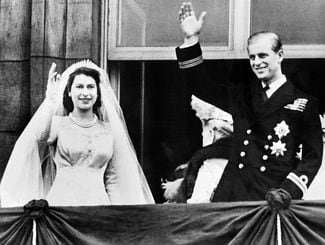 Recém-casados, Elizabeth e Philip acenam da sacada do Palácio de Buckingham. Foto: AFP.
