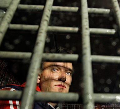 FILE - Alexei Navalny is seen behind the bars in the police van after he was detained during protests in Moscow Tuesday, May 8, 2012, a day after Putin's inauguration. Russian opposition leader Alexei Navalny has been convicted of fraud and contempt of court and sentenced to nine years in a maximum security prison. A judge also ruled Tuesday March 22, 2022 that Navalny would have to pay a fine of 1.2 million rubles (about $11,500). Navalny is currently serving another prison sentence of 2 1/2 years in a prison colony east of Moscow. (AP Photo/Sergey Ponomarev, File)