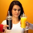 Girl choosing between orange juice and soda, vitamin drink or unhealthy diet. Foto: motortion/Adobe Stock 