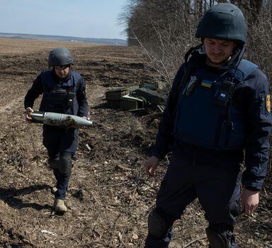 Ukrainians investigate a bombing site in Bezruky, Ukraine, near Kharkiv, April 7, 2022. In recent days, the scatterable mines, banned under international law, have begun turning up in Ukraine, imperiling civilians even in areas where Russian troops have withdrawn. (Tyler Hicks/The New York Times)