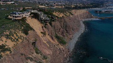 Imagem aérea mostra as casas na beira de um penhasco acima do Oceano Pacífico após um deslizamento de terra.