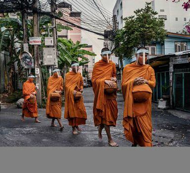 Monges com máscaras vão a templo em Bangkok