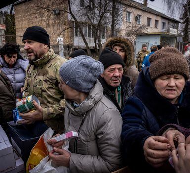 Residents crowd a pick-up truck distributing aid in Borodyanka, Ukraine, on Tuesday, April, 5, 2022. As many as 200 people are missing and presumed dead under the rubble of this small town that has been devastated by Russian airstrikes, the acting mayor said Tuesday. (Ivor Prickett/The New York Times)