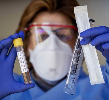 Laboratorista mostra kit de teste para o coronavírus na Europa