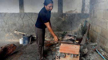 A dona de casa Endy Perez cozinha no quintal de sua casa em um fogão à lenha improvisado, em Maracay, Venezuela. Foto: Manaure Quintero/Reuters
