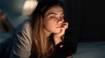 Addicted young woman chatting and surfing on the Internet with smartphone late at night in bed. Insomnia and mobile addiction. Foto: mtrlin/Adobe Stock 