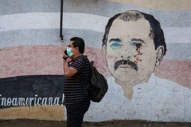Un hombre pasa junto a un mural destrozado por el presidente Daniel Ortega en Managua el 7 de enero.