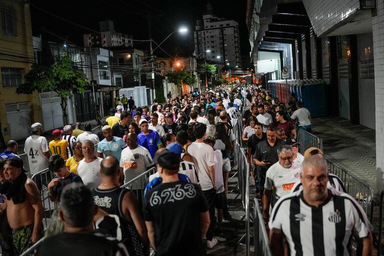 Torcedores fazem fila para prestar suas homenagens ao Rei Pelé na Vila Belmiro, em Santos.