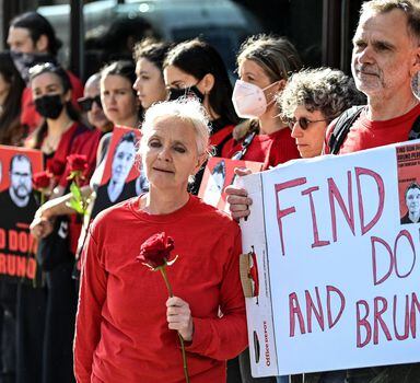 Sian Phillips together with Gareth Phillips, siblings of missing journalist Dom Phillips hold a placard and a rose, as demonstrators protest following the disappearance, in the Amazon, of their brother Dom Phillips and campaigner Bruno Araujo Pereira, outside the Brazilian Embassy in London, Britain, June 9, 2022. REUTERS/Toby Melville