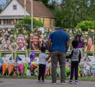 FILE — People visit a makeshift memorial near the Tops supermarket where a racist mass shooting took place, in Buffalo, N.Y., May 23, 2022. The man accused of carrying out the massacre has been charged with 25 counts of murder, domestic terrorism and other charges in relation to the May 14 shooting, which left 10 Black residents dead. (Hiroko Masuike/The New York Times)
