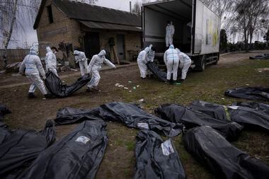 Imagem mostra voluntários recolhendo corpos de civis em Bucha, próximo de Kiev, no início de abril. Cenas revelaram possíveis crimes de guerra cometido pela Rússia durante a invasão na Ucrânia