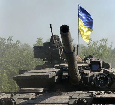 TOPSHOT - Ukrainian troop ride a tank on a road of the eastern Ukrainian region of Donbas on June 21, 2022, as Ukraine says Russian shelling has caused "catastrophic destruction" in the eastern industrial city of Lysychansk, which lies just across a river from Severodonetsk where Russian and Ukrainian troops have been locked in battle for weeks. - Regional governor Sergiy Gaiday says that non-stop shelling of Lysychansk on June 20 destroyed 10 residential blocks and a police station, killing at least one person. (Photo by Anatolii Stepanov / AFP)