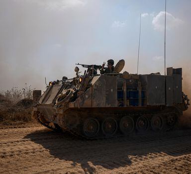 An Israeli soldier flashes a V-sign from an APC as they head towards the Gaza Strip border in southern Israel on Friday, Oct.13, 2023. (AP Photo/Ariel Schalit)