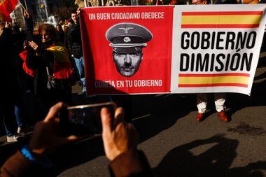 Cartaz em protesto em Madrid contra o governo de esquerda diz: 'um bom cidadão obedece. Confia no teu governo', e pede a demissão do gabinete 