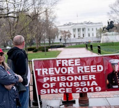 (FILES) In this file photo taken on March 30, 2022, Paula and Joey Reed, parents of Trevor Reed, stand next to a banner reading “Free Trevor Reed” in Lafayette Square near the White House in Washington, DC. - Russia and the US announced a prisoner swap on April 27, 2022, despite fierce tensions over Ukraine, with Moscow handing over ex-Marine, Trevor Reed, in exchange for a Russian pilot convicted of drug smuggling. Reed, a 30-year-old from Texas who was jailed in Russia in 2020, was exchanged for Konstantin Yaroshenko, 53, who had been serving a 20-year US prison sentence since 2011. (Photo by Stefani Reynolds / AFP)