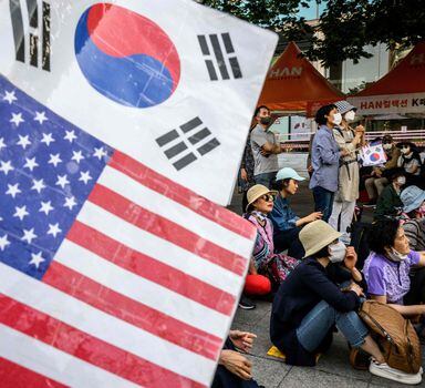 Sul-coreanos agitam bandeiras dos EUA e da Coreia do Sul durante visita do presidente Joe Biden ao país