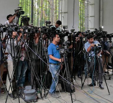 Jornalistas de Bangladesh cobrem procedimentos do lado de fora de um tribunal em Dhaka, Bangladesh