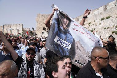 Multidão segura uma faixa representando a jornalista veterana da Al Jazeera, Shireen Abu Akleh, enquanto caminha da Cidade Velha de Jerusalém para seu local de sepultamento Foto: Ariel Schalit/AP
