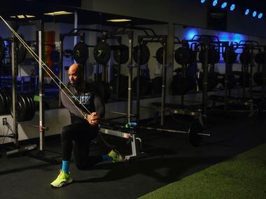 Gerard Burley, ou Treinador G, estica suas faixas de exercícios para maior resistência durante um treino.