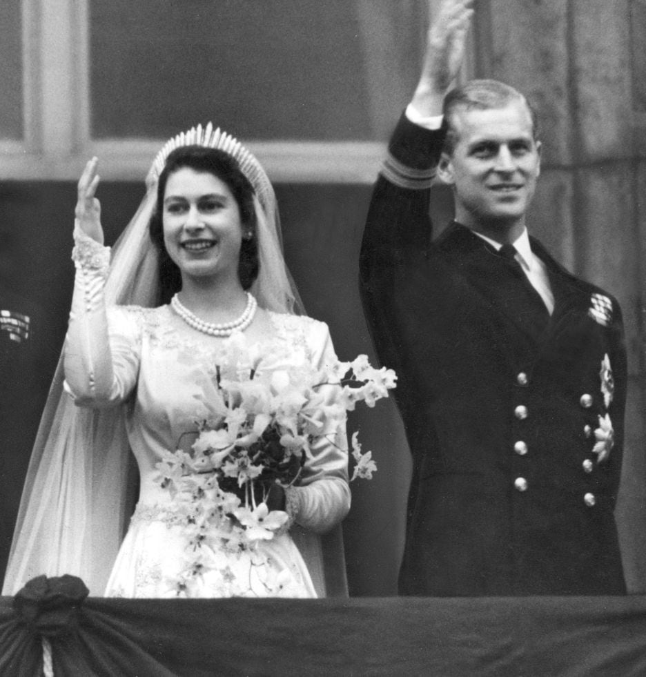 Rainha Elizabeth II e príncipe Philip acenam para seus súditos de sacada no Palácio de Buckingham.