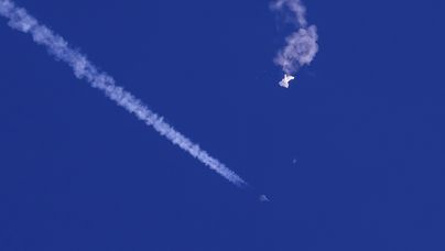 In this photo provided by Chad Fish, the remnants of a large balloon drift above the Atlantic Ocean, just off the coast of South Carolina, with a fighter jet and its contrail seen below it, Saturday, Feb. 4, 2023. The downing of the suspected Chinese spy balloon by a missile from an F-22 fighter jet created a spectacle over one of the states tourism hubs and drew crowds reacting with a mixture of bewildered gazing, distress and cheering. (Chad Fish via AP). Foto: Chad Fish
