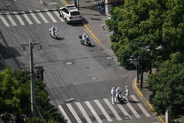 Policiais fazem posto de controle em rua durante lockdown em Xangai nesta segunda-feira.