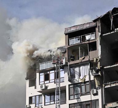 Rescuers and firefighters work in a damaged residential building, hit by Russian missiles in Kyiv on June 26, 2022, amid Russian invasion of Ukraine. - "The G7 summit must respond with more sanctions against Russia and more heavy weapons for Ukraine," urged on June 26, 2022 Dmytro Kouleba, the head of Ukrainian diplomacy, on Twitter, calling for "defeating the sick Russian imperialism." (Photo by Genya SAVILOV / AFP)